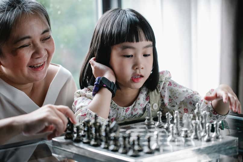 madre soltera ensena a nina a jugar ajedrez 
