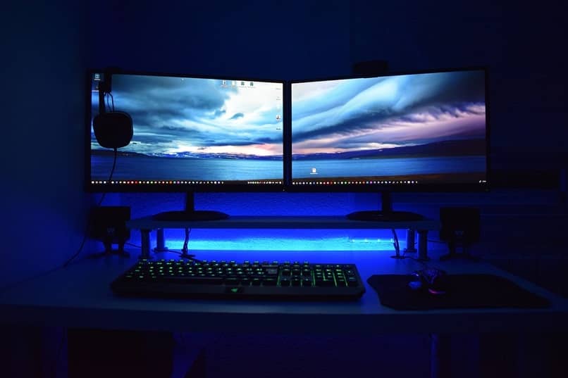 two monitors on desk in blue background