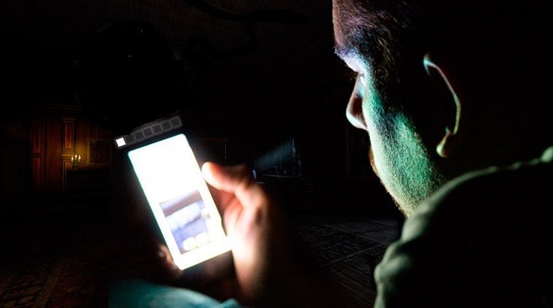 man using his iphone in the dark