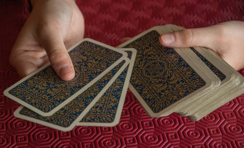 manos con un mazo de cartas del tarot de marsella