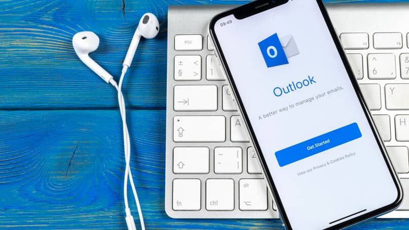 Audifonos con un teclado y un celular en Outlook