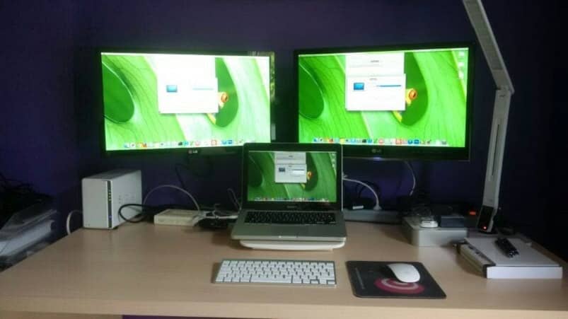 tres monitores mac sobre escritorio