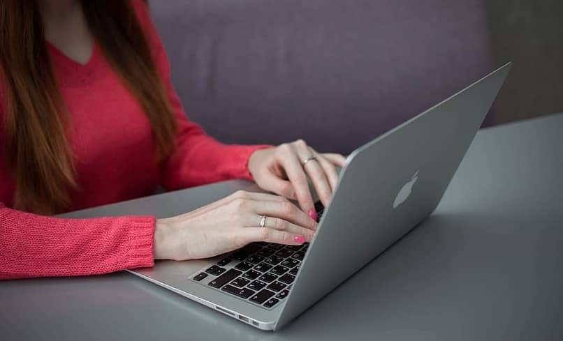 mujer escribiendo en su laptop