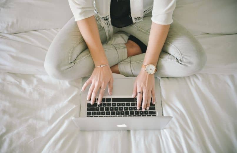 mujer escribiendo en una mac