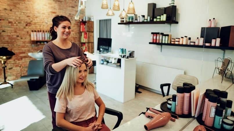 peluquera realizando peinado a una clienta