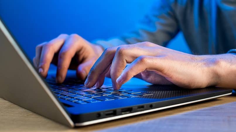 hombre escribiendo en una laptop